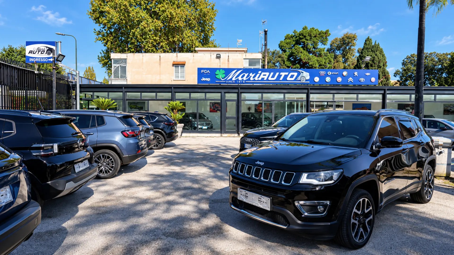 Piazzale del concessionario Mariauto con le auto in esposizione e l'insegna MariAUTO